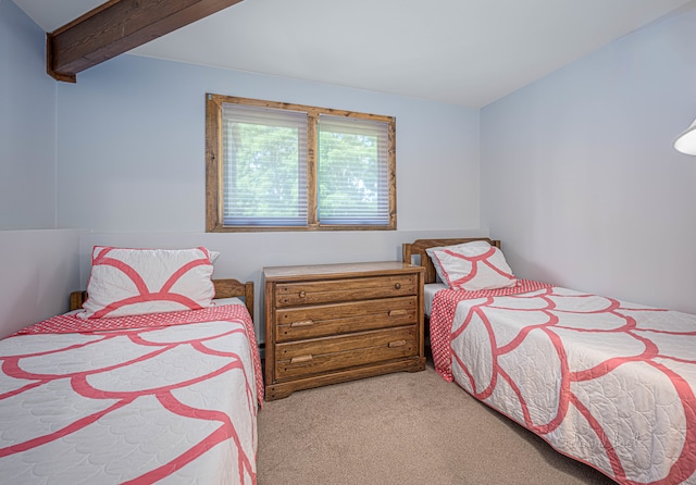 carpeted bedroom featuring beam ceiling