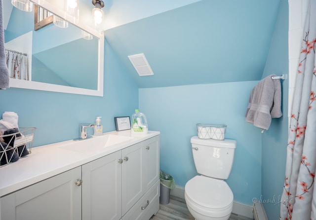 bathroom featuring vanity, wood-type flooring, lofted ceiling, and toilet