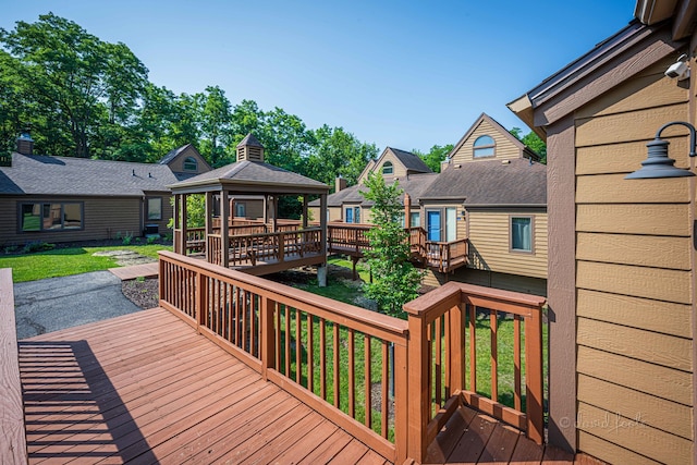 wooden terrace featuring a yard and a gazebo