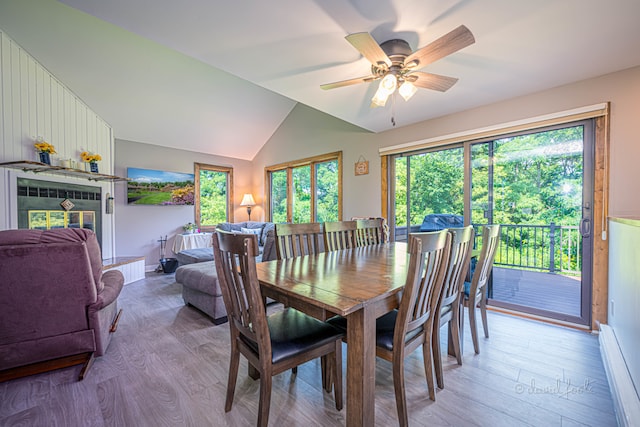 dining area featuring lofted ceiling, a baseboard radiator, ceiling fan, and wood-type flooring