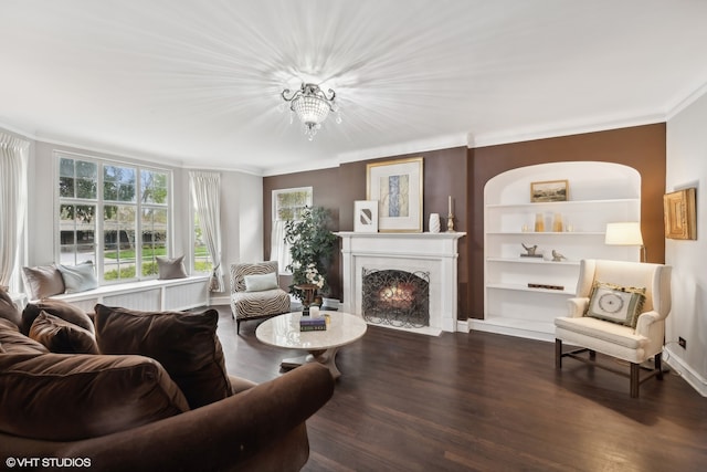 living room with crown molding, built in features, and dark hardwood / wood-style flooring