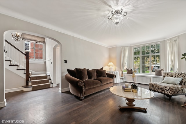 living room with plenty of natural light, dark hardwood / wood-style floors, and a chandelier