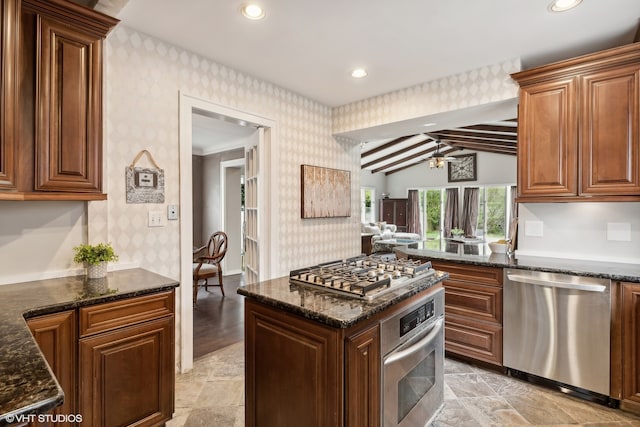 kitchen with dark stone counters, vaulted ceiling with beams, appliances with stainless steel finishes, and light tile patterned floors