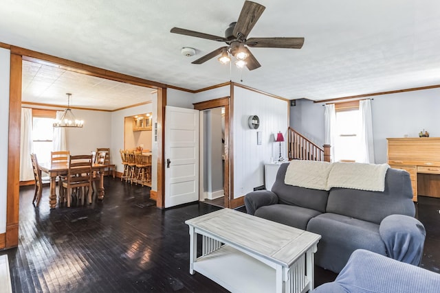 living room featuring crown molding, dark hardwood / wood-style floors, and ceiling fan with notable chandelier