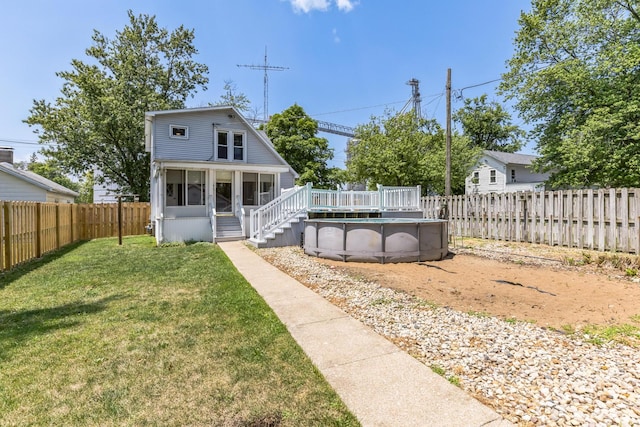 back of house featuring a fenced in pool and a yard