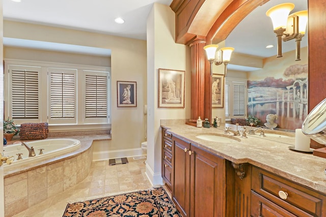 bathroom featuring vanity, a relaxing tiled tub, and toilet