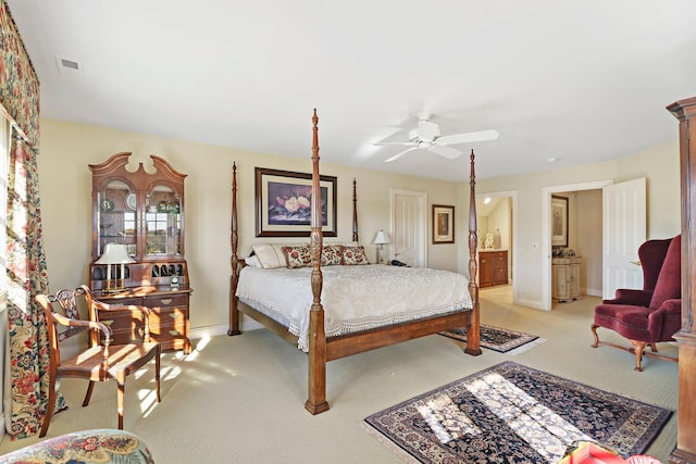 carpeted bedroom featuring ceiling fan and ensuite bath