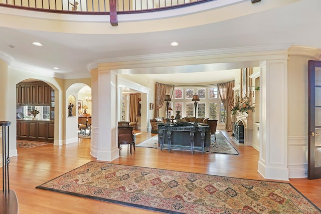 foyer entrance featuring crown molding and light wood-type flooring