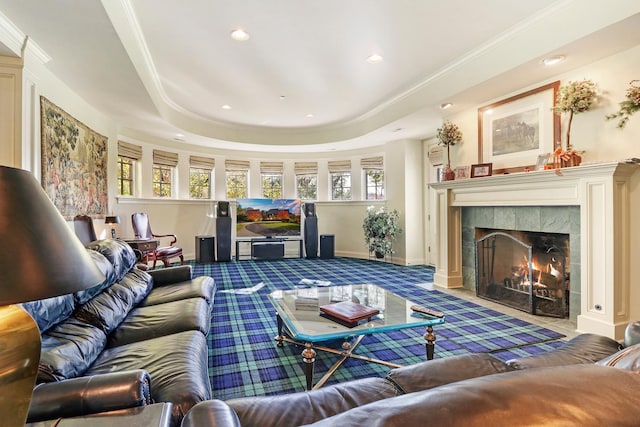 living room featuring a tray ceiling, a tile fireplace, and carpet flooring