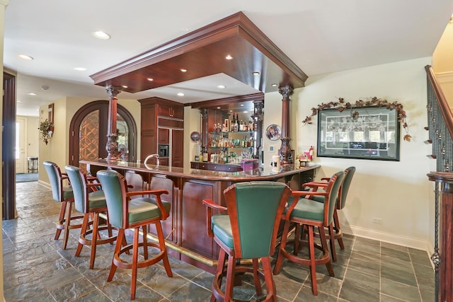 bar featuring paneled built in refrigerator