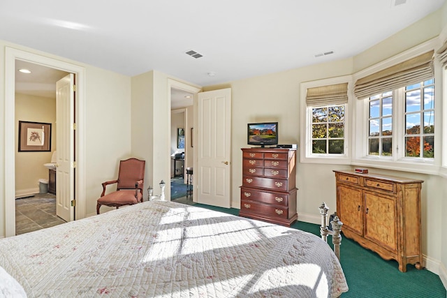 bedroom with ensuite bathroom and carpet