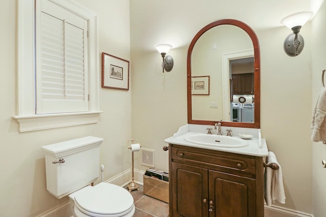 bathroom with vanity, tile patterned floors, washer and clothes dryer, and toilet