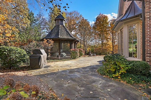 view of patio with grilling area and a sunroom