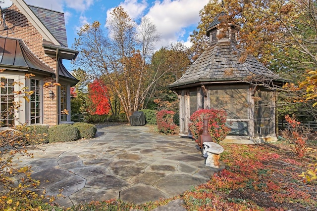 view of patio with a grill and a sunroom