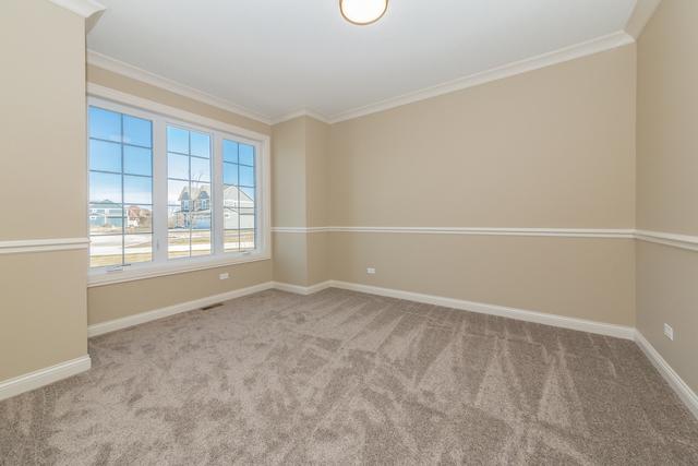 unfurnished room with light carpet and crown molding