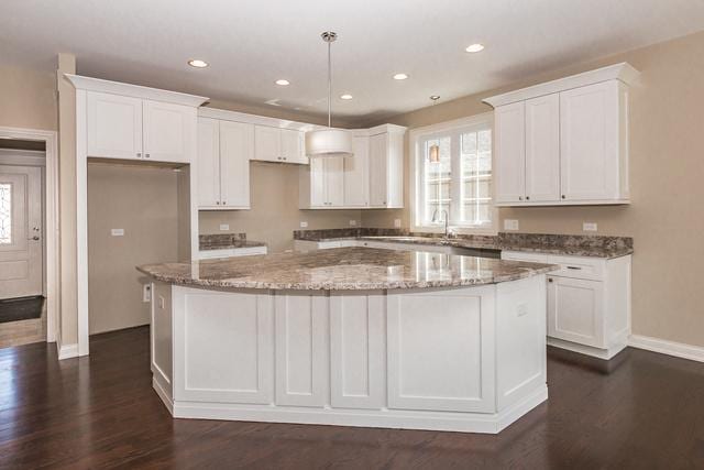 kitchen featuring a wealth of natural light, a center island, and white cabinets