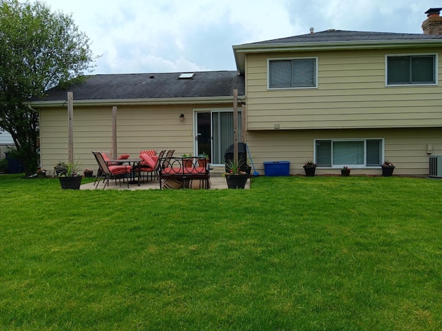 back of house with central air condition unit, a patio area, and a lawn