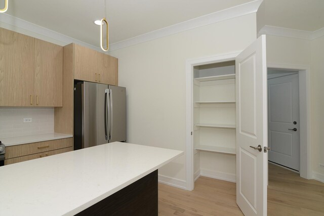 kitchen featuring tasteful backsplash, light brown cabinets, and stainless steel appliances