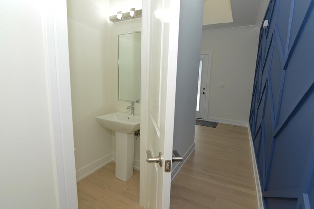 hall featuring crown molding and light hardwood / wood-style flooring