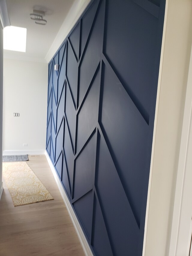 entrance foyer with light hardwood / wood-style flooring and crown molding