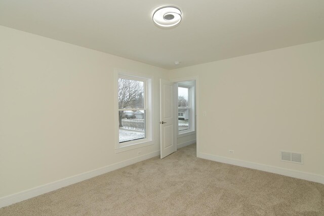 unfurnished bedroom featuring light colored carpet and a closet