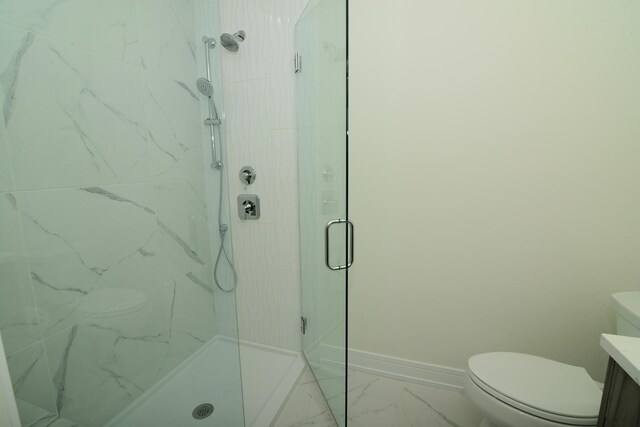 bathroom with a shower with door, vanity, and toilet