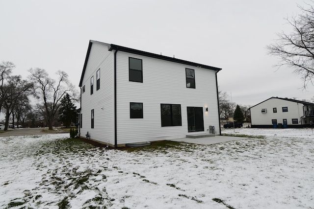 view of snow covered back of property