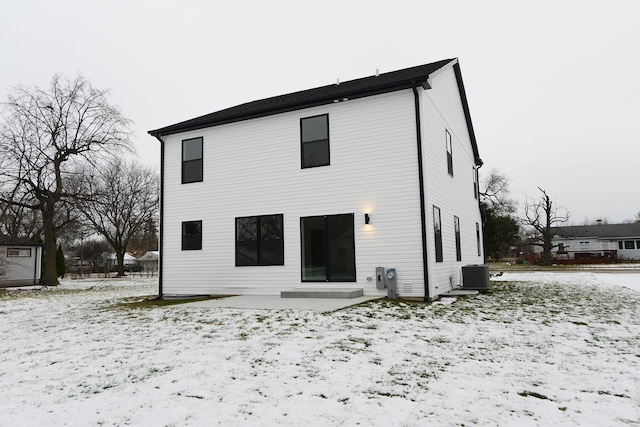 snow covered rear of property with cooling unit