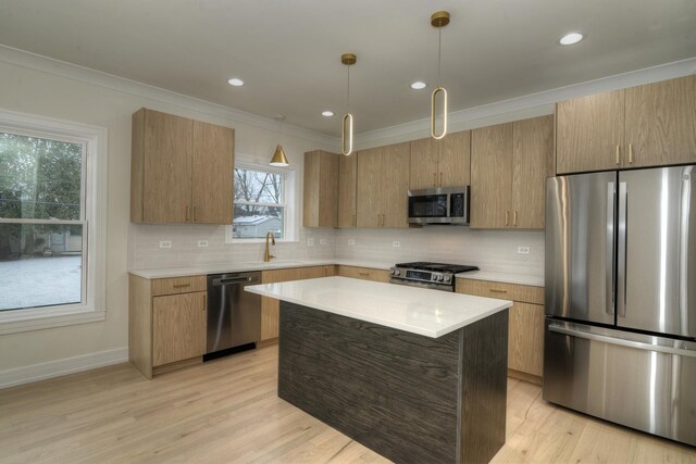 kitchen featuring decorative backsplash, appliances with stainless steel finishes, sink, decorative light fixtures, and a kitchen island