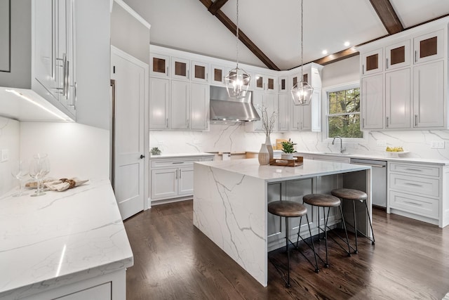 kitchen featuring wall chimney range hood, white cabinetry, a center island, and stainless steel dishwasher