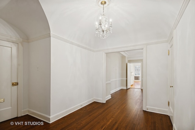 hall featuring ornamental molding, dark wood-type flooring, and a notable chandelier