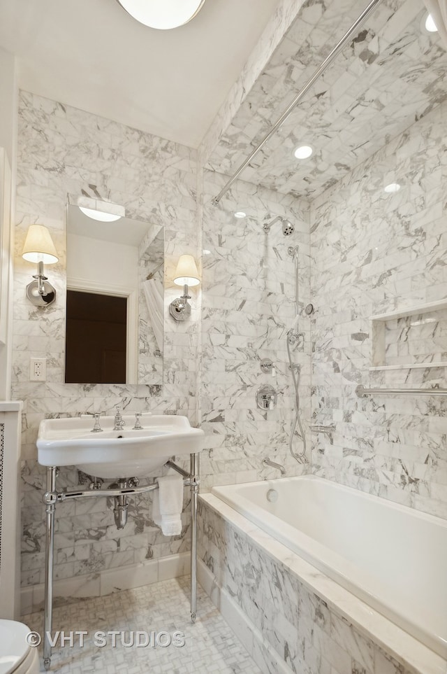 bathroom with tile walls and tiled bath