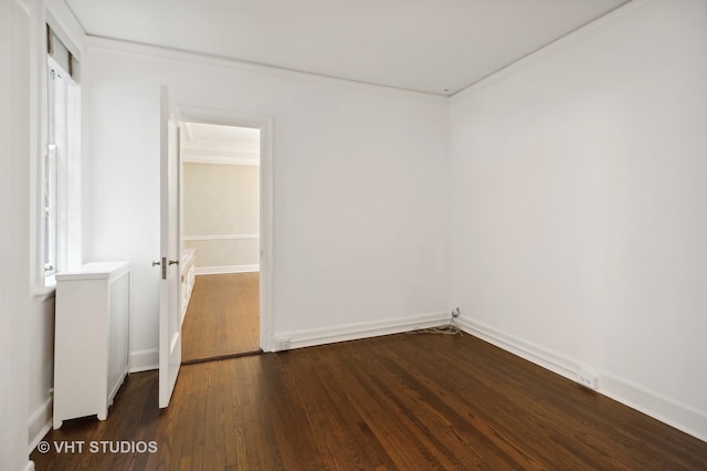 unfurnished room with ornamental molding and dark wood-type flooring