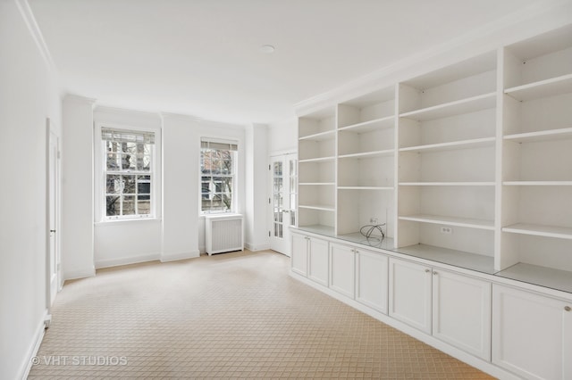 carpeted empty room featuring radiator and ornamental molding