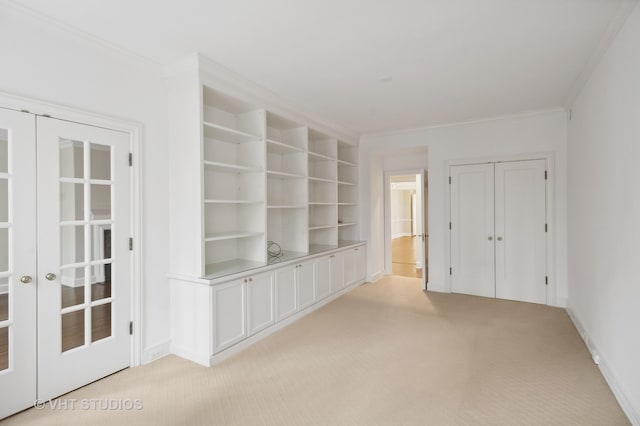 carpeted spare room with crown molding and french doors