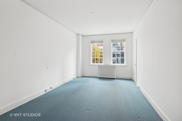 carpeted spare room featuring radiator heating unit