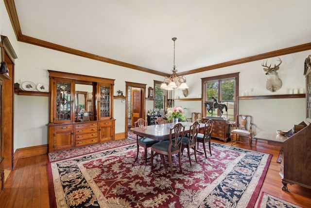 dining area featuring ornamental molding, an inviting chandelier, and hardwood / wood-style flooring