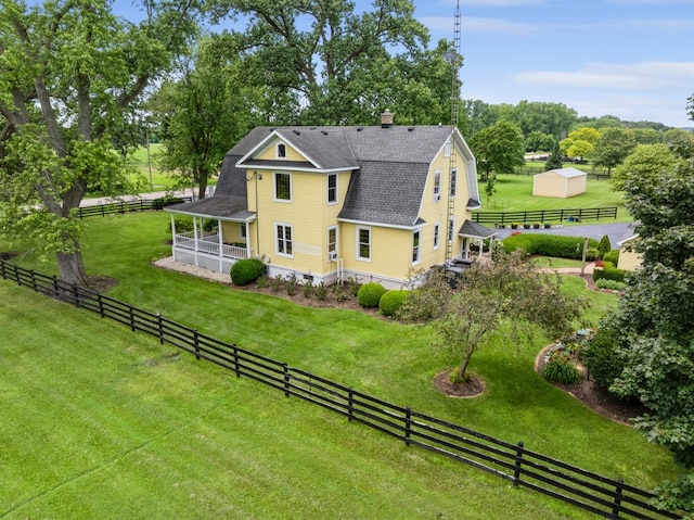 rear view of property with a lawn and a rural view