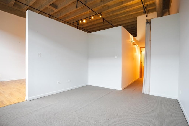 spare room featuring carpet flooring and rail lighting