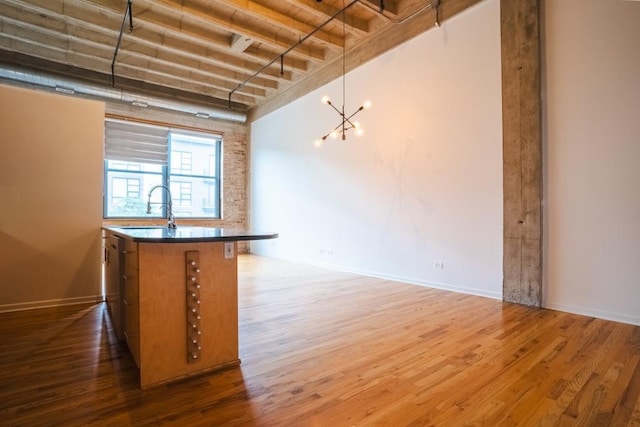 interior space featuring sink, decorative light fixtures, a chandelier, a high ceiling, and dark hardwood / wood-style floors