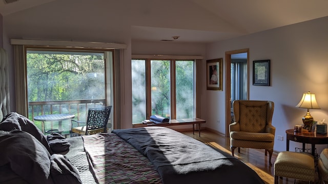 bedroom with wood-type flooring and vaulted ceiling