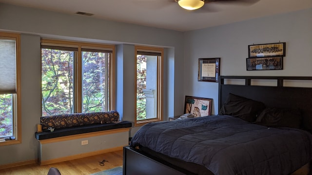 bedroom featuring multiple windows, light wood-type flooring, and ceiling fan