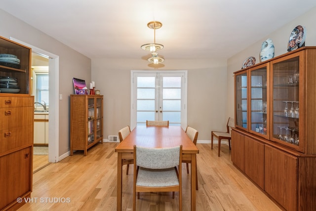 dining area featuring light wood-type flooring and french doors