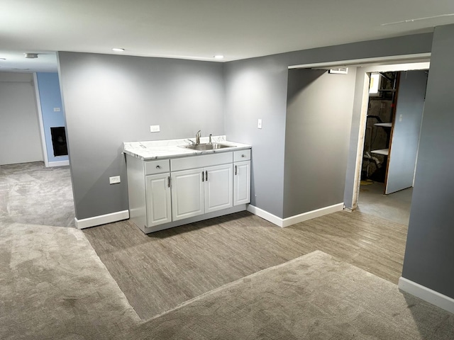 interior space with a sink, light wood-style flooring, and baseboards