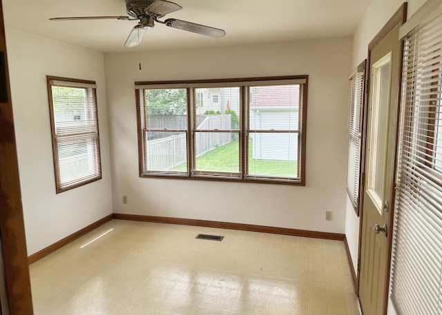 unfurnished room featuring light floors, a ceiling fan, visible vents, and baseboards