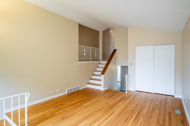 interior space featuring light hardwood / wood-style floors and high vaulted ceiling