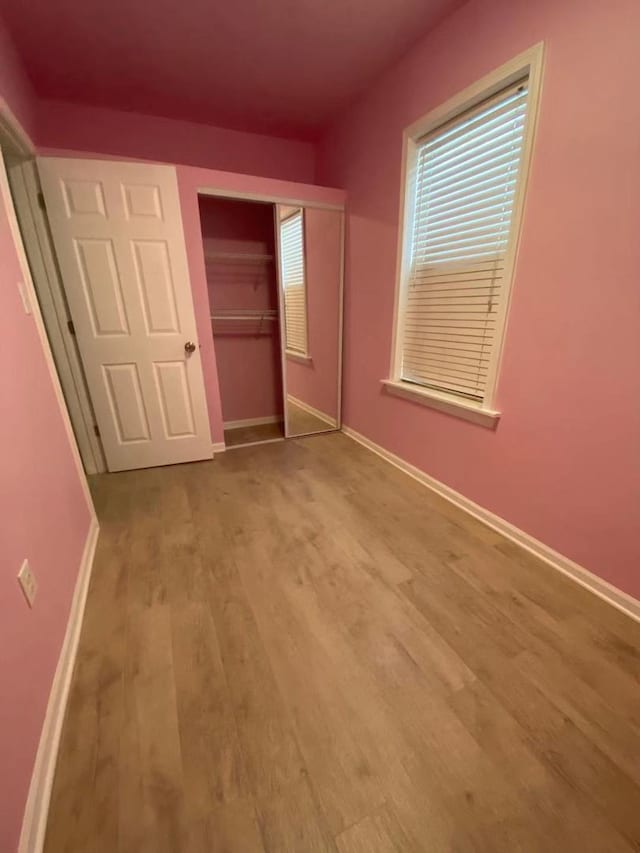 unfurnished bedroom featuring light hardwood / wood-style floors and a closet