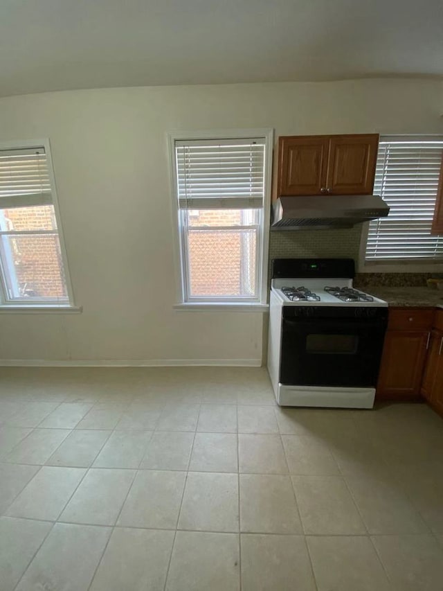 kitchen featuring light tile patterned floors and gas range