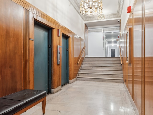 hallway with elevator and an inviting chandelier