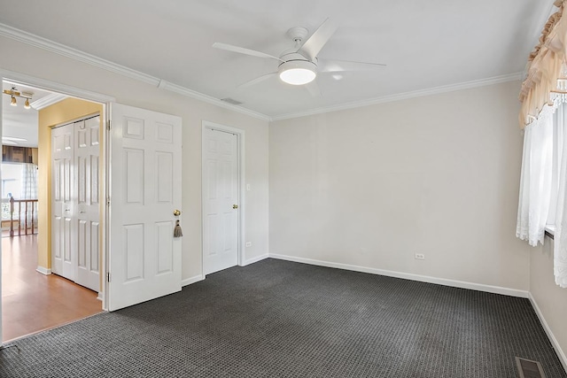 unfurnished bedroom featuring dark carpet, ceiling fan, and crown molding